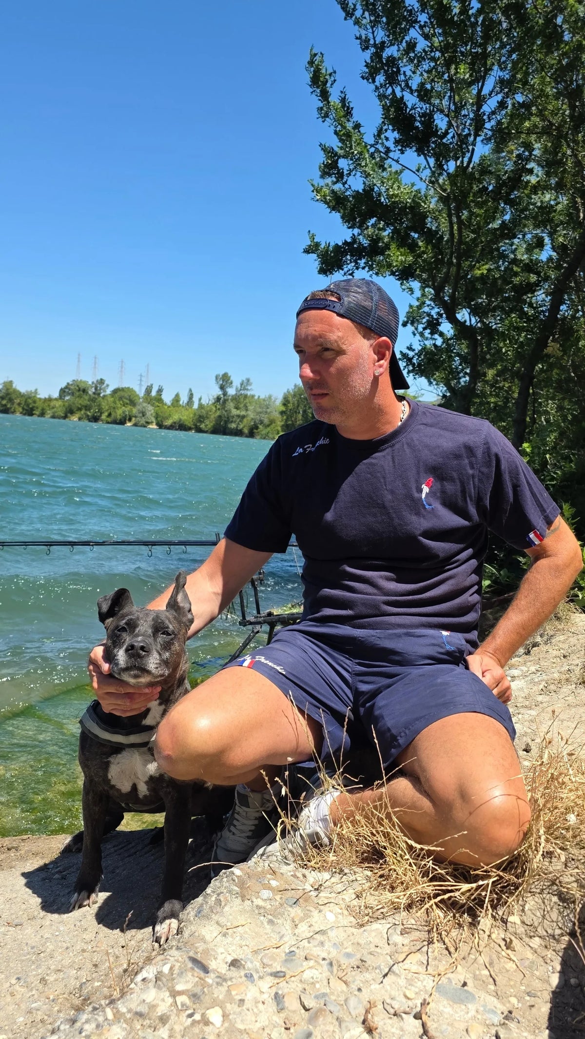 Connected Carper Frenchie trucker cap with breathable mesh back and embroidered logo, worn by a man fishing outdoors.