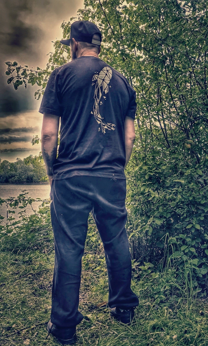 Connected Carper black t-shirt with a large white geometric carp fish design on the back, worn by a man by a lake.