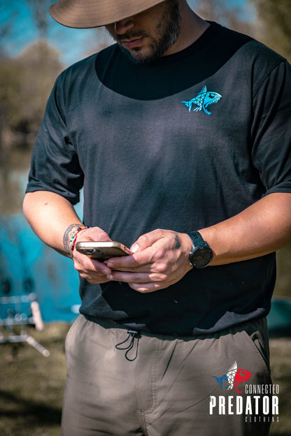 Connected Carper black cotton-blend T-shirt with blue fish logo on chest, worn by a man outdoors near water