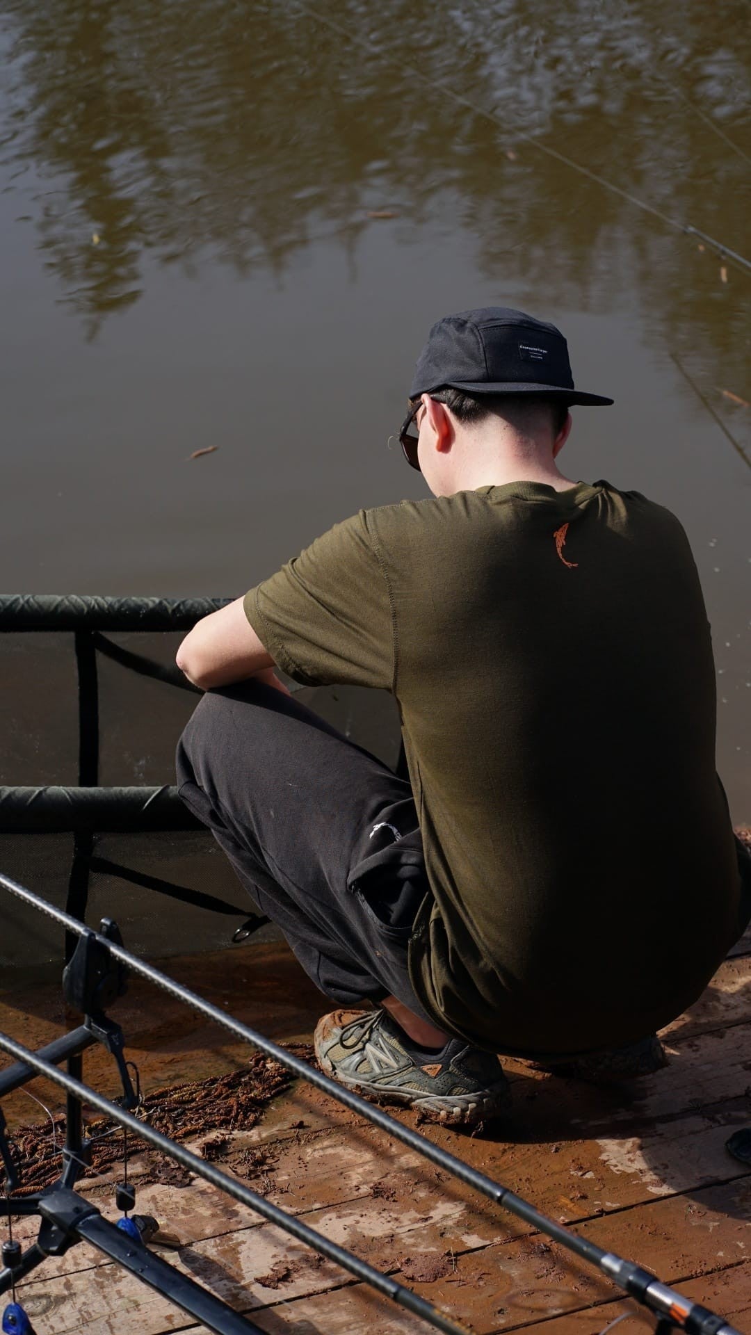 Homme portant le jogging noir Connected Carper en coton lors d'une session de pêche au bord de l'eau