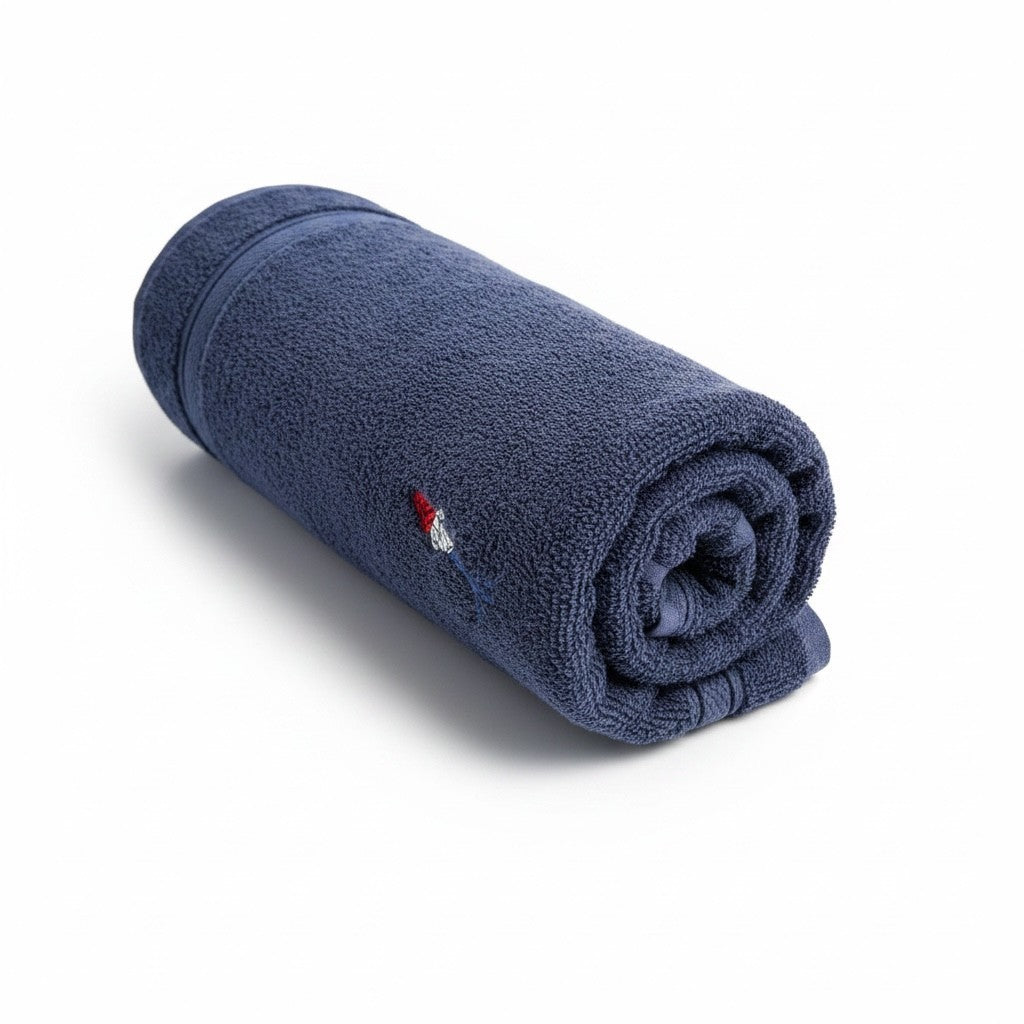 Connected Carper navy blue cotton towel rolled up with a small embroidered logo detail on a white background