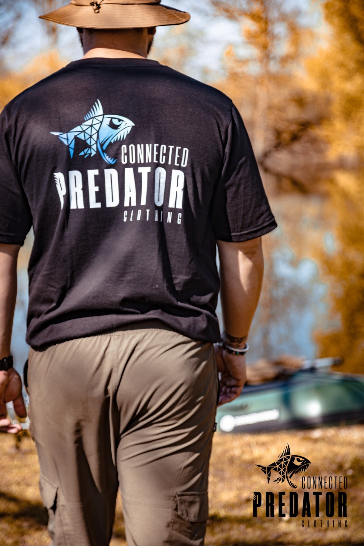 Connected Carper black cotton-blend t-shirt with blue and white Predator graphic on back, worn by man outdoors