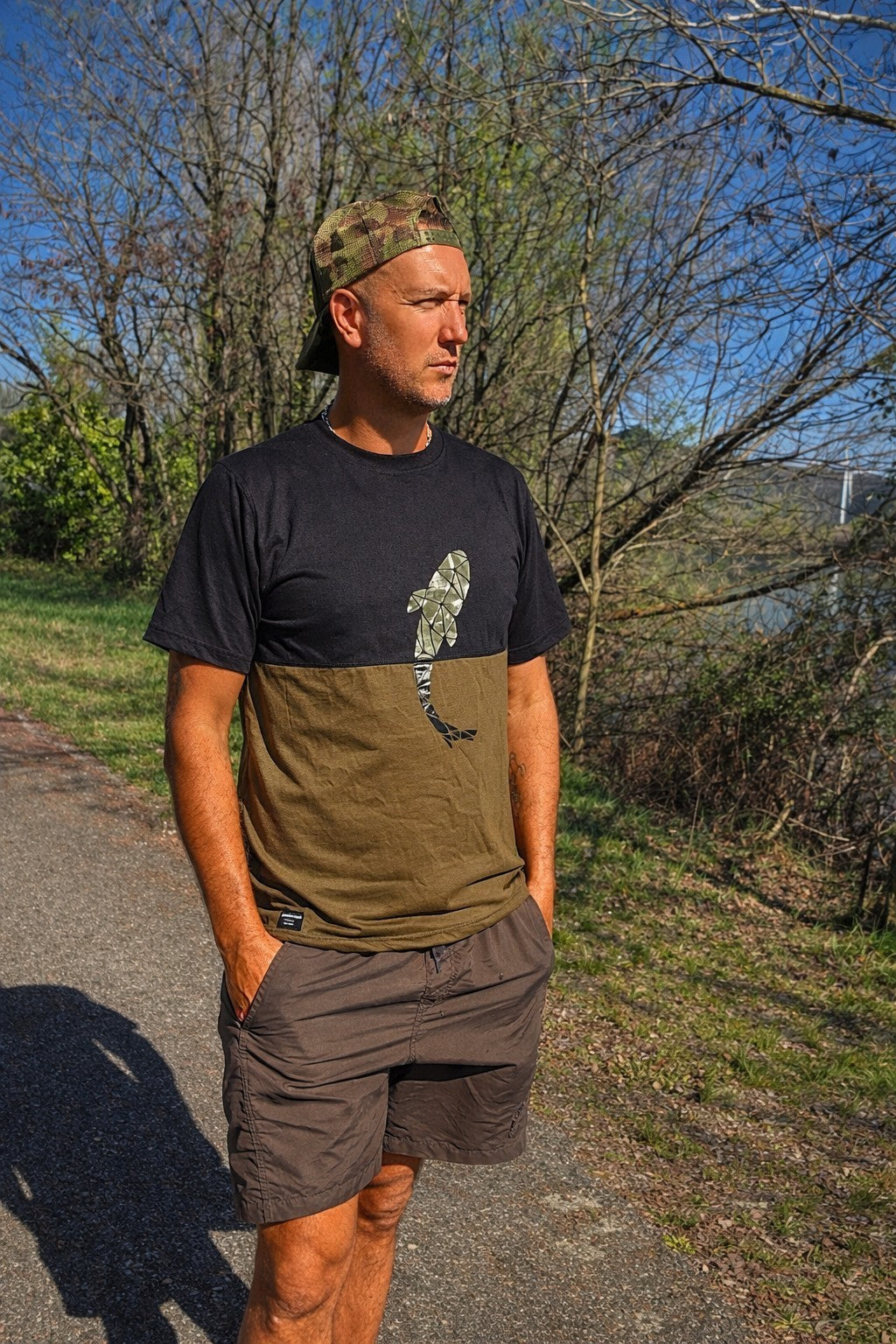 Connected Carper two-tone khaki and black cotton blend fishing t-shirt with carp logo worn by a man outdoors